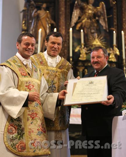 2012.10.07_10.22.26.jpg - Pfarrer P.Laurentius Resch und Abt Berthold Heigl überreichen Karl Nußbaumer für 45 Jahre Mesnerdienst den Hippolytorden in Bronze.