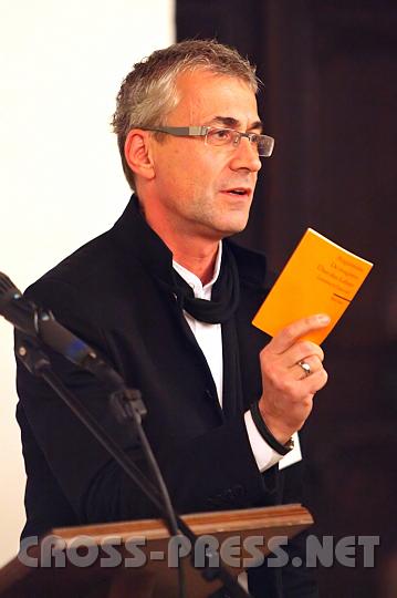 2009.11.20_17.01.35.jpg - Prof. Univ.-Doz. Dr. Andreas Schnider vom Institut f�r Praktische Theologie, das die Tagung organisierte, pr�sentiert die Besonderheiten des Instituts:   hier eines der 3 B�cher von Augustinus, "De Magistro", das zur Grundlagenliteratur f�r Katechetik z�hlt. "Bei uns geschieht einerseits eine Wahrnehmung und Kontemplation der Praxis, andererseits wird in der Praxis und aus der Praxis heraus Theologie betrieben, eingebettet in die Spiritualit�t der Zisterzienserhochschule."