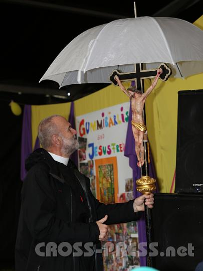 2012.07.21_09.05.25.jpg - P.Josef Kranzl "beschirmt" das Kreuz, mit dem er zusammen mit einigen Mutigen die Fußwallfahrt auf den Pöllauberg bei strömendem Regen anführte.