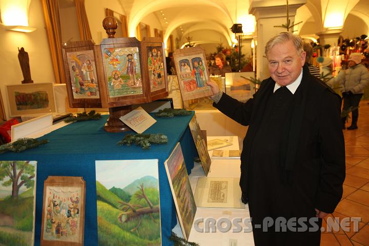 2009.12.13_17.40.20.jpg - P.Martin Mayrhofer zeigt, umgeben von anderen Werken, eines der austauschbaren Bilder seiner Jahreskrippe.