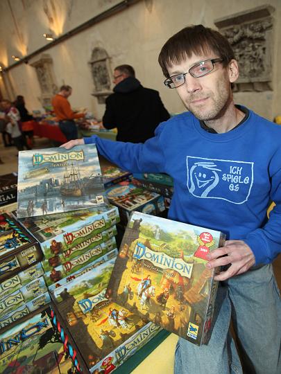 2009.12.08_12.35.23.jpg - Ein Spielekenner-Team half den Familien bei der Auswahl der Spiele und den Regeln.  Hier ein Stapel der 3 Versionen des Spieles des Jahres 2009 "Dominion".