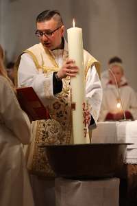 OsterNachtFeier in Haag Pfarrer Vidovic taucht die Osterkerze in Wasser ein.